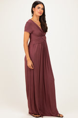 woman wearing a burgundy short sleeve maxi dress with a twist front and flowy skirt