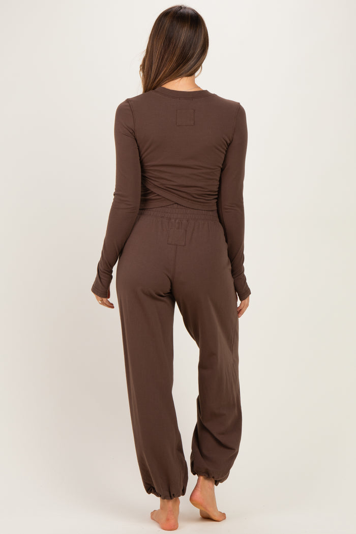 woman wearing a brown long sleeve maternity loungewear set with cinched pants and a relaxed fit