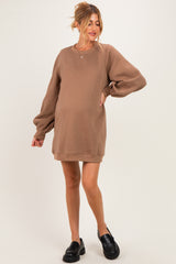 woman wearing a brown maternity sweatshirt dress with long puff sleeves and a visible baby bump