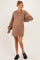 woman wearing a brown maternity sweatshirt dress with long puff sleeves and a visible baby bump