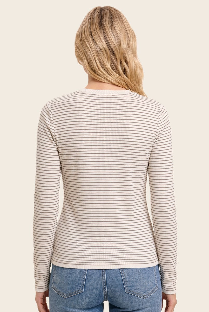 woman wearing a beige and cream striped long sleeve top, viewed from the back, paired with light blue jeans