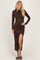 woman wearing a brown long sleeve bodycon dress with a thigh-high slit and styled hair