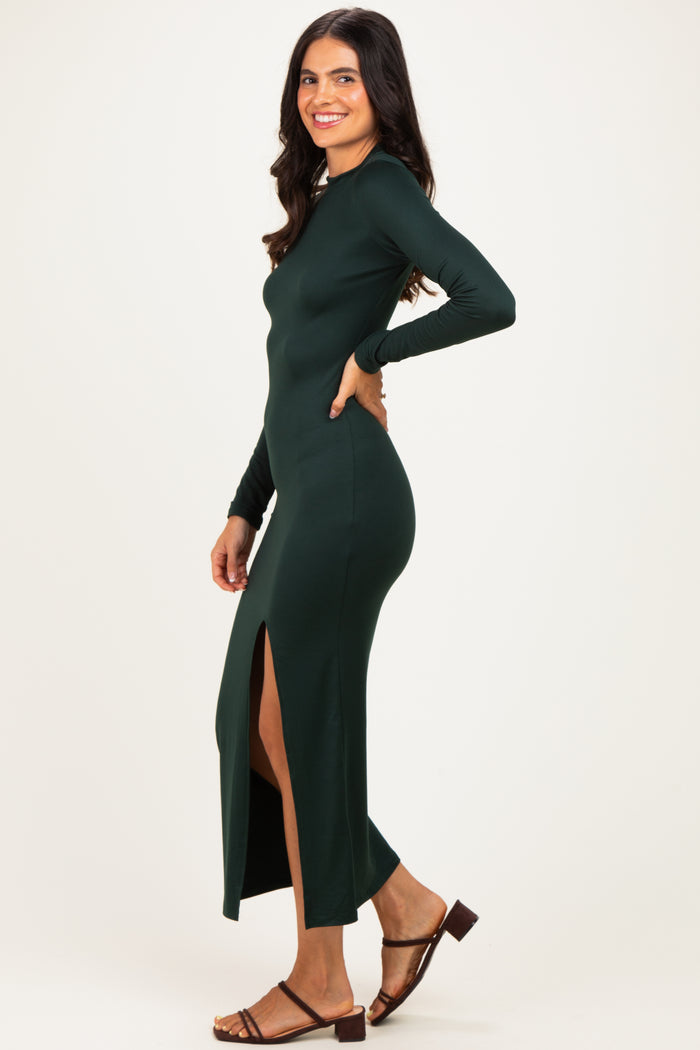 woman wearing a dark green long sleeve maxi dress with a side slit and brown sandals