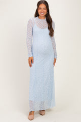 woman wearing a light blue lace maternity maxi dress with long sleeves and a visible baby bump