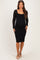 woman wearing a black lace long sleeve maternity dress, showing her baby bump