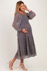 woman wearing a floral print long sleeve maternity dress with a tiered skirt, showing her baby bump