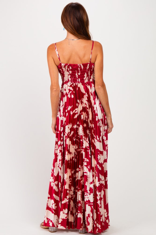 woman wearing a red floral maxi dress with a smocked back and pleated skirt