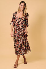 woman wearing a floral midi dress with short sleeves and a sweetheart neckline against a beige background
