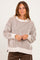woman wearing a beige and brown striped oversized sweater with long sleeves and a relaxed fit