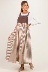 woman wearing a brown and white striped maternity maxi dress with a fitted bodice and loose skirt, showing off her baby bump