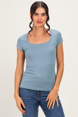 woman wearing a light blue short sleeve scoop neck top and blue jeans