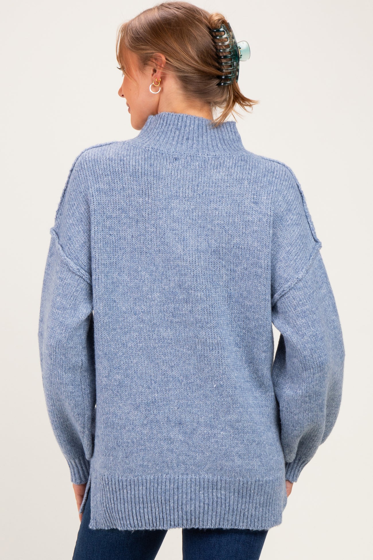 woman wearing a light blue oversized maternity sweater with a high neck and dropped shoulders