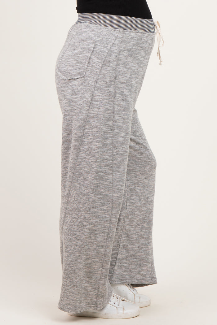 woman wearing gray maternity jogger pants with a drawstring waist and side pockets, showing a baby bump