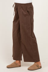maternity wear brown wide-leg pants with an elastic waistband and pockets, styled with a casual look