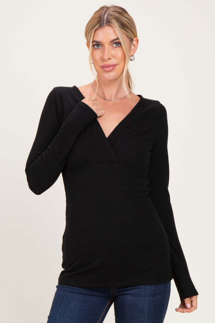 woman wearing a black long sleeve wrap top with a fitted waist and v-neckline