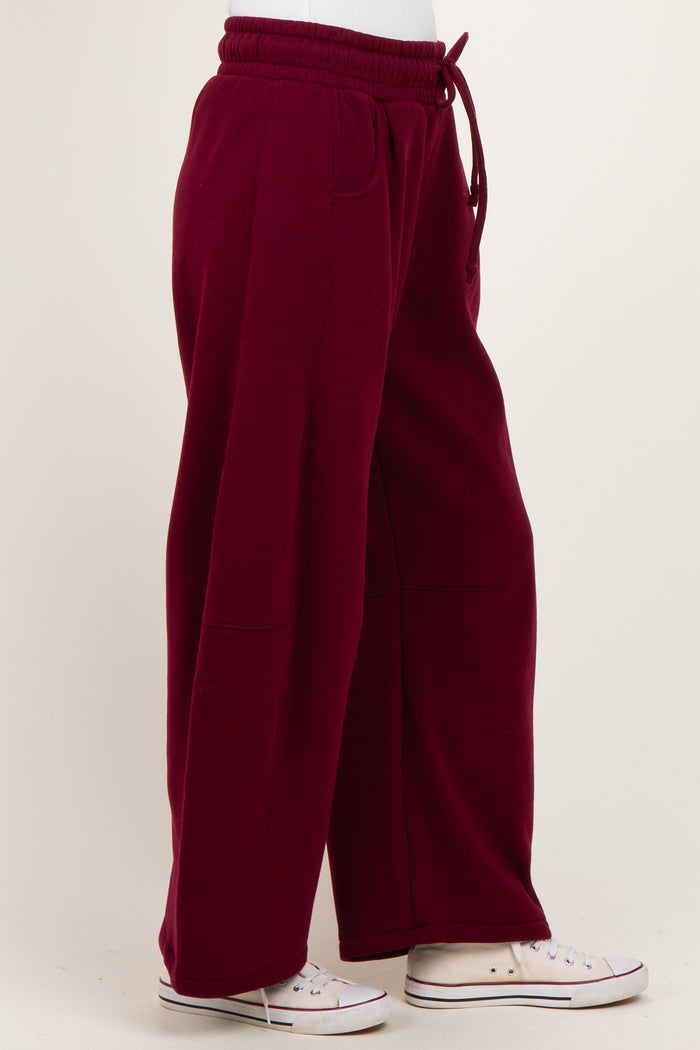 woman wearing burgundy wide-leg sweatpants with a drawstring waist and side pockets