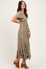 woman wearing a brown floral maxi dress with short sleeves and a cinched waist, styled with brown heeled sandals