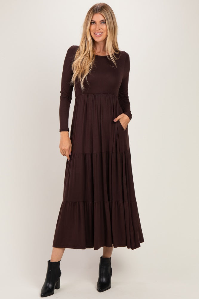 woman wearing a brown long sleeve tiered maxi dress with pockets and black ankle boots