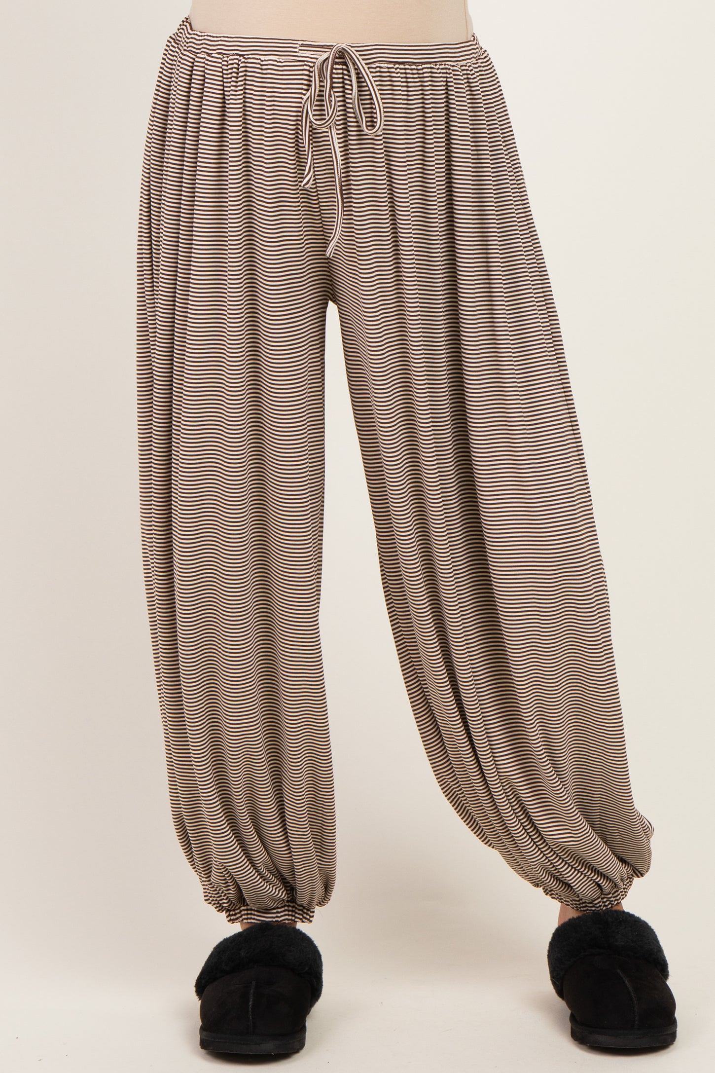 maternity wear striped harem pants with an elastic waist and cuffed ankles, model wearing fuzzy slippers