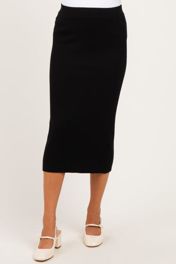 woman wearing a black ribbed maternity skirt with a fitted silhouette and mid-calf length
