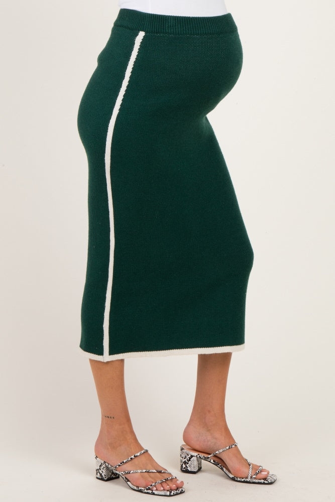 woman wearing a green maternity skirt with a white side stripe and a visible baby bump