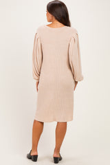 woman wearing a beige ribbed maternity dress with puffed long sleeves, shown from the back