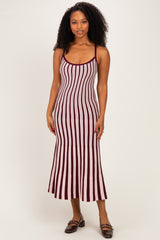 woman wearing a maroon and white striped midi dress with spaghetti straps and a fitted silhouette