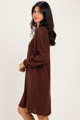 woman wearing a brown long sleeve knit dress with a relaxed fit and side pockets
