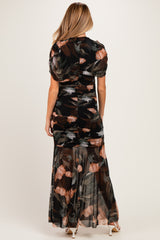 woman wearing a black floral maternity maxi dress with a ruched back and short puff sleeves
