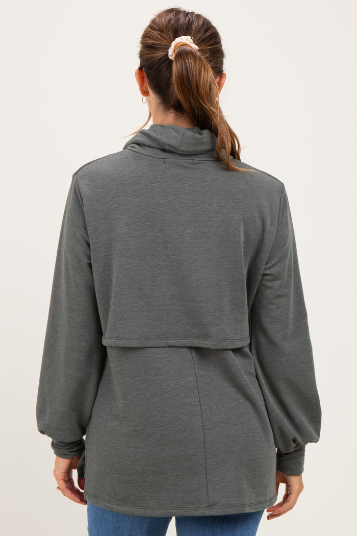 woman wearing a dark gray maternity top with a high neck and balloon sleeves, displaying a relaxed fit from the back