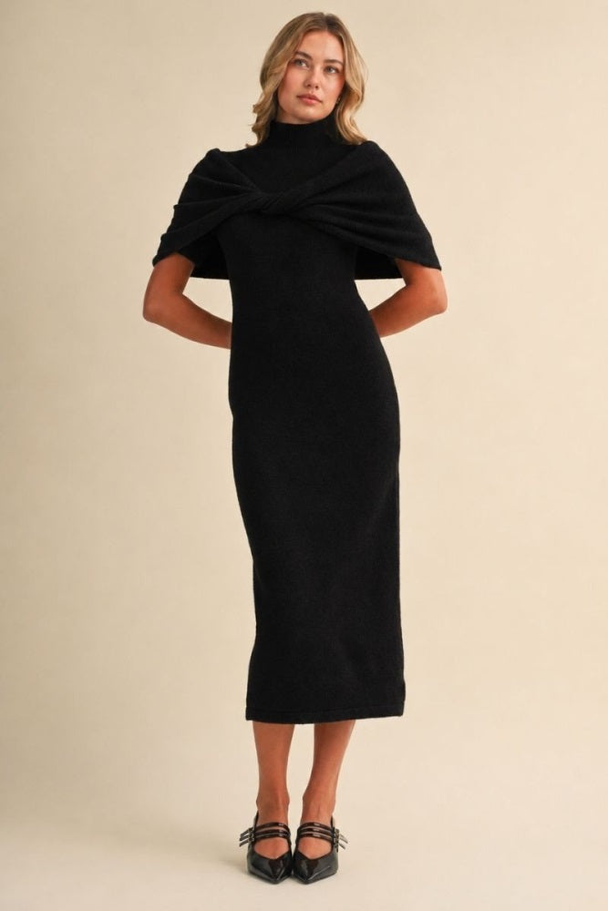 woman wearing a black knitted midi dress with a unique twisted neckline and cap sleeves