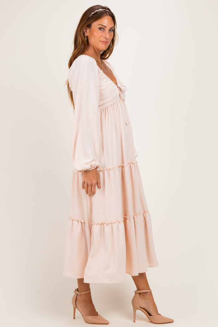 woman wearing a soft pink long sleeve midi dress with a tiered skirt and heels