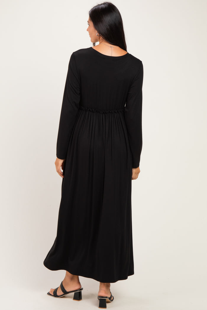 woman wearing a black long sleeve maxi dress with a gathered waist, shown from the back