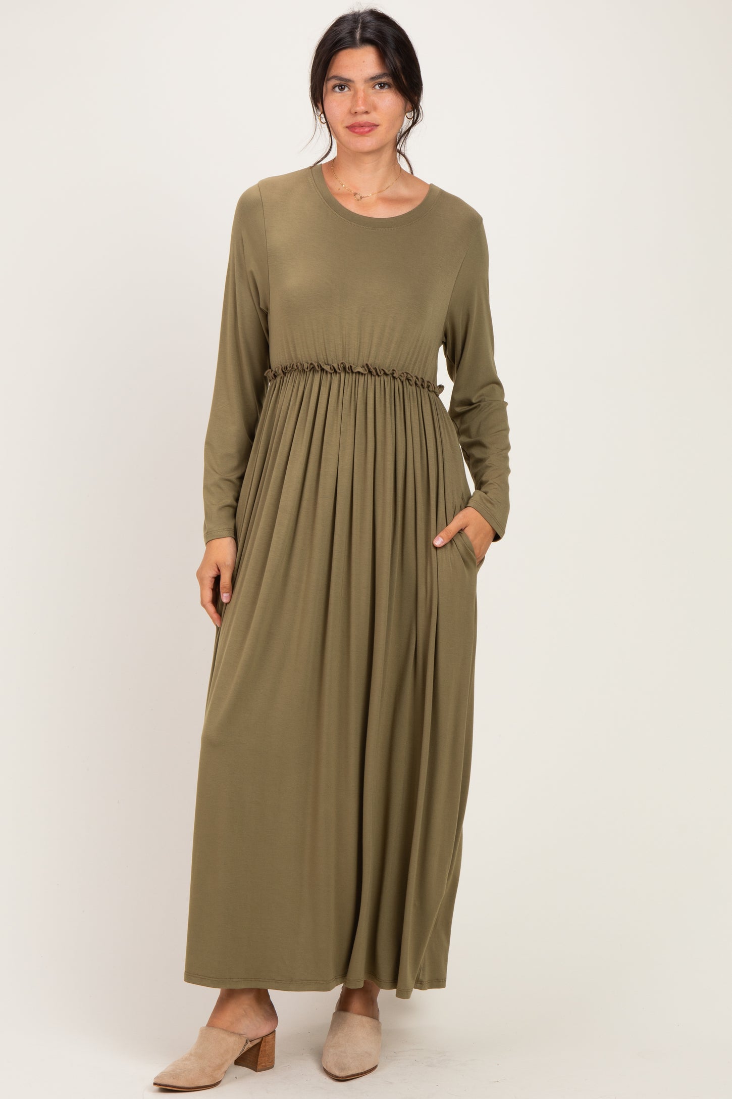 woman wearing an olive green long sleeve maxi dress with a gathered waist and pockets