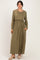woman wearing an olive green long sleeve maxi dress with a gathered waist and pockets