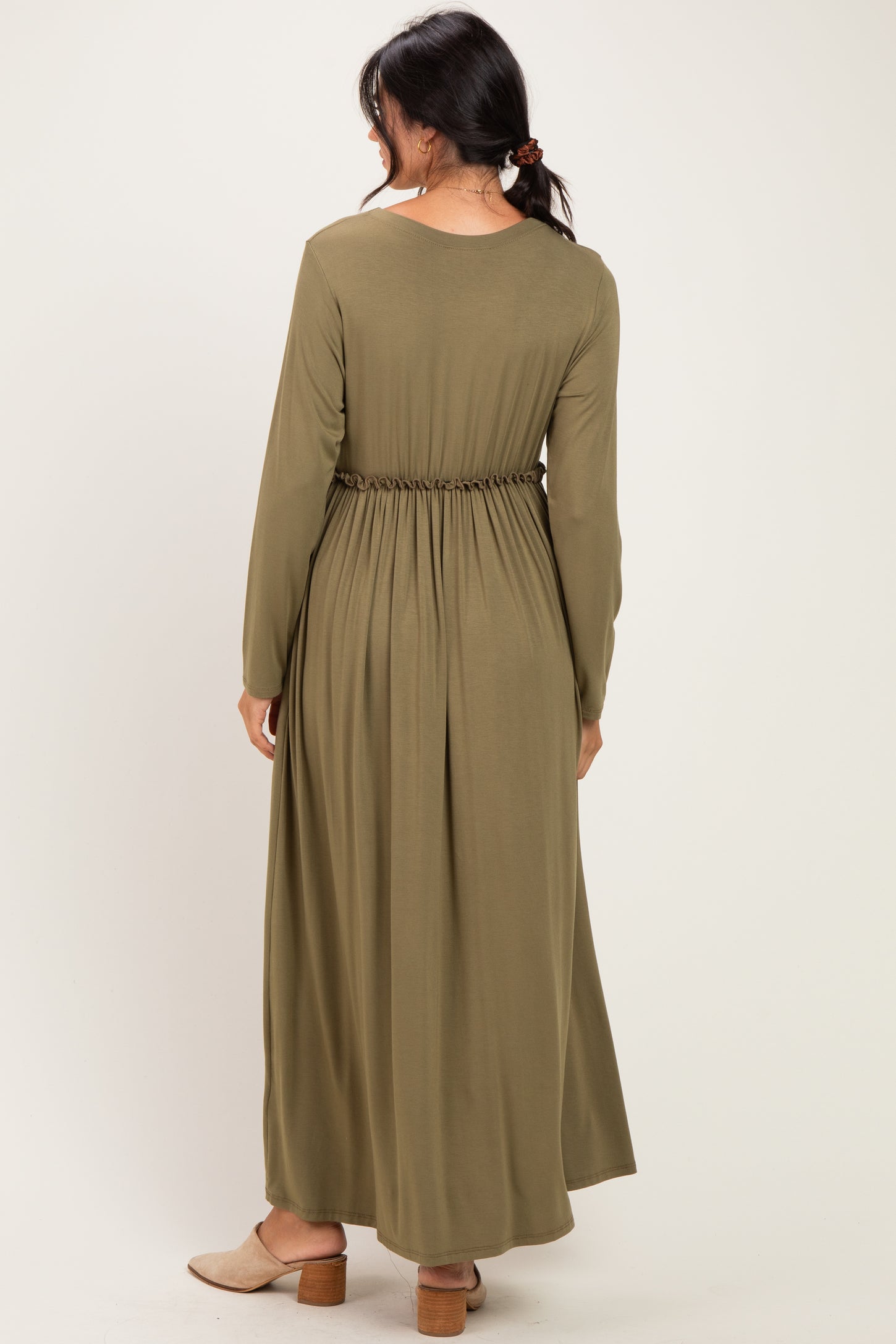woman wearing an olive green long sleeve maxi dress with a cinched waist and flowing skirt