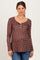 woman wearing a brown floral maternity top with a henley neckline and long sleeves, showing her baby bump