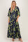 woman wearing a navy blue maxi dress with floral print and kimono sleeves, styled with heels