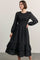 woman wearing a black floral long sleeve dress with smocked bodice and tiered ruffle hem