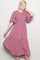 woman wearing a dusty pink short sleeve smocked dress with a tiered skirt and flutter sleeves