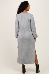 woman wearing a gray ribbed maternity sweater dress with side slits and long sleeves, showcasing her baby bump