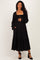 woman wearing a black maternity maxi dress with smocked bodice and ruffled sleeves, smiling and displaying her baby bump