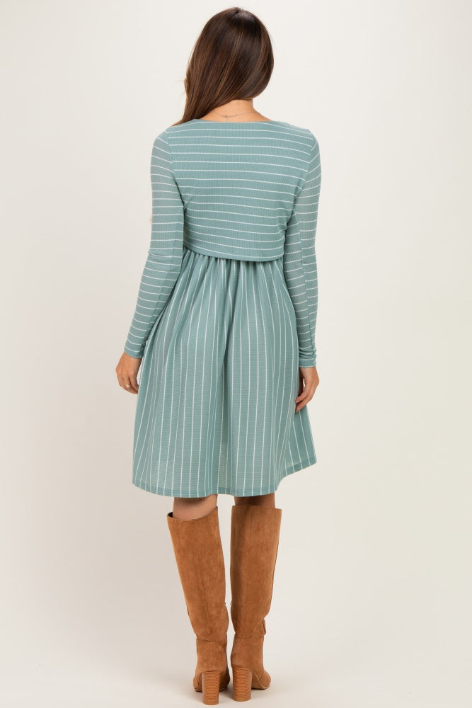 woman wearing a teal and white striped long sleeve maternity dress with a fitted bodice and flared skirt, back view