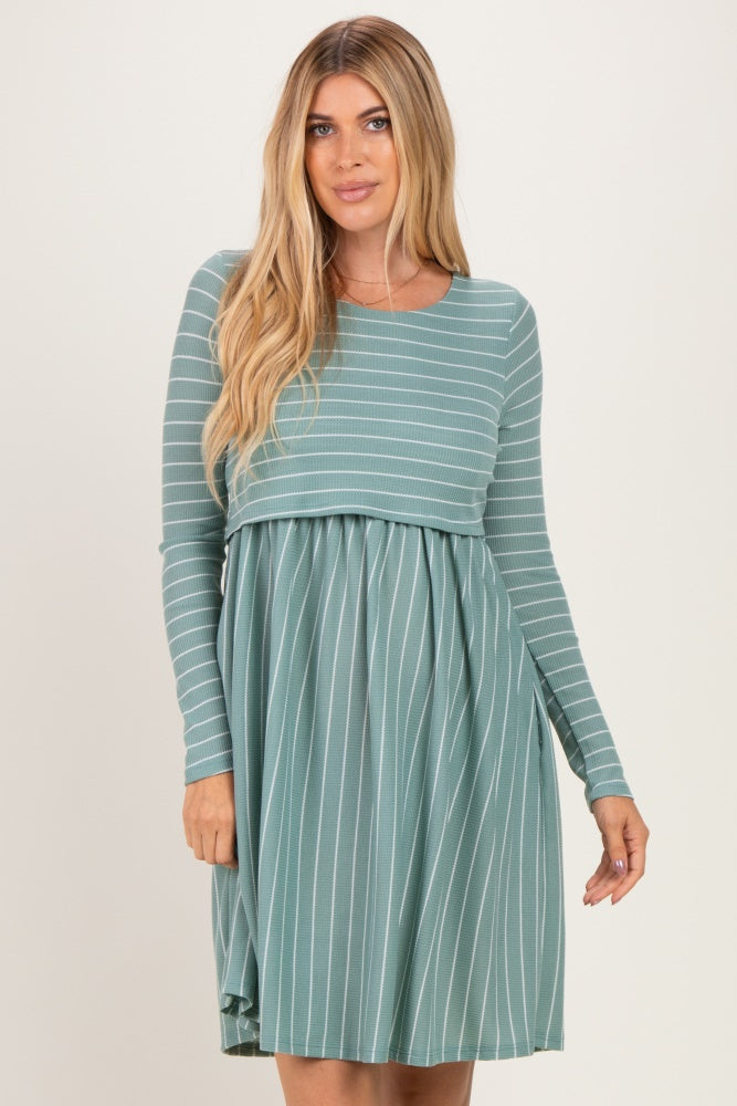 woman wearing a green striped long sleeve dress with a fitted top and flowy skirt