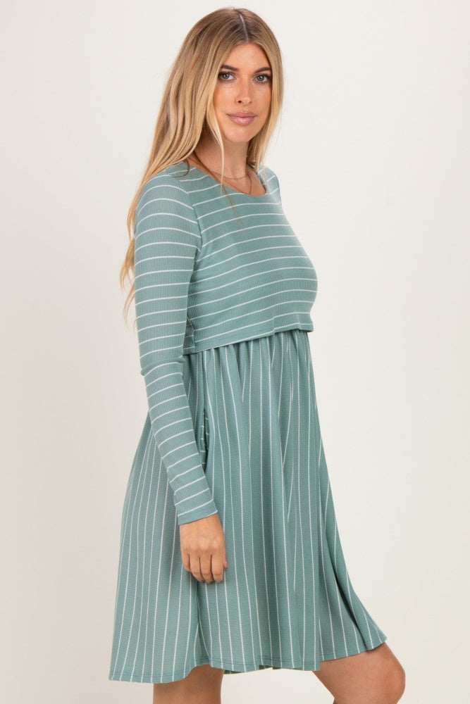 woman wearing a teal striped long sleeve dress with a fitted bodice and flared skirt