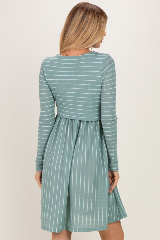 woman wearing a green and white striped long sleeve dress with a fitted bodice and flared skirt