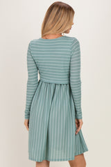 woman wearing a green and white striped long sleeve dress with a fitted bodice and flared skirt