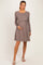 woman wearing a brown striped long sleeve maternity dress and holding her baby bump