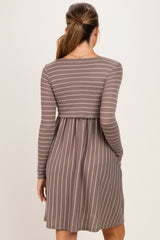 woman wearing a brown and white striped long sleeve maternity dress with a fitted bodice and flared skirt
