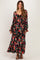 woman wearing a black floral maternity maxi dress with long sleeves and a baby bump visible